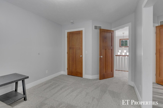 12150 W Devis Rd, West Olive, MI 49460 - unfurnished bedroom featuring a chandelier and carpet
