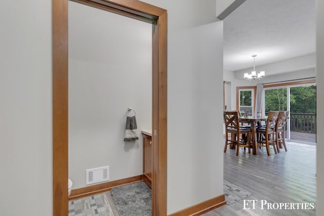 12150 W Devis Rd, West Olive, MI 49460 - hall with light wood-type flooring and a chandelier