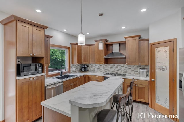12150 W Devis Rd, West Olive, MI 49460 - kitchen featuring wall chimney range hood, stainless steel appliances, a center island, light wood-style floors, and tasteful backsplash
