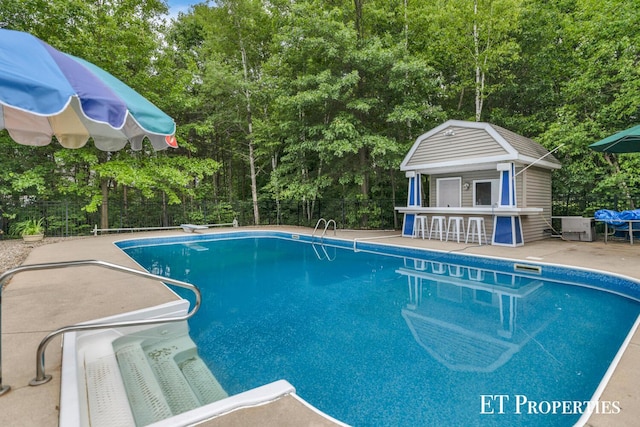 12150 W Devis Rd, West Olive, MI 49460 - view of pool with a patio area, an outdoor structure, and an exterior structure