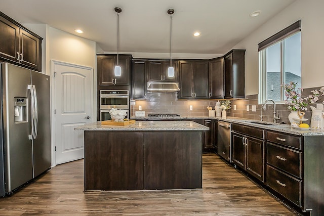 2767 St Regis Way, Ann Arbor, MI 48105 - kitchen with stainless steel appliances, under cabinet range hood, dark brown cabinets, a kitchen island, and recessed lighting