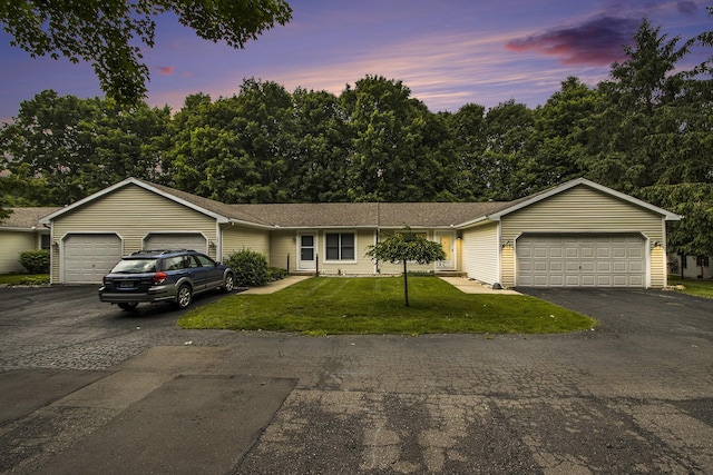 5973 Woodsong Way, Kalamazoo, MI 49009 - ranch-style home featuring a garage, asphalt driveway, and a front lawn