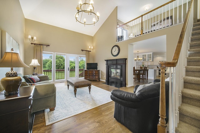 712 Dornoch Dr, Ann Arbor, MI 48103 - living area with a chandelier, high vaulted ceiling, stairs, wood finished floors, and a multi sided fireplace