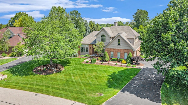 712 Dornoch Dr, Ann Arbor, MI 48103 - view of front of property with brick siding, a front lawn, a chimney, and driveway