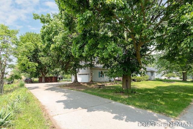 3747 Leonard St NW, Grand Rapids, MI 49534 - obstructed view of property featuring a garage, a front yard, and asphalt driveway