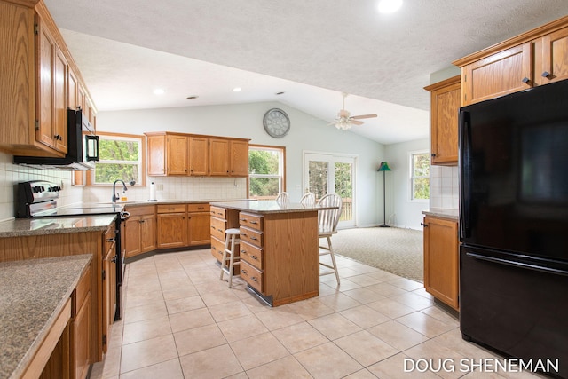 3747 Leonard St NW, Grand Rapids, MI 49534 - kitchen featuring freestanding refrigerator, range with electric cooktop, lofted ceiling, a breakfast bar, and a ceiling fan