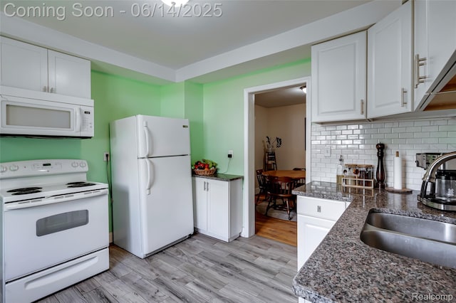 1217 E Madge Ave, Hazel Park, MI 48030 - kitchen featuring white appliances, white cabinets, a wood stove, and decorative backsplash