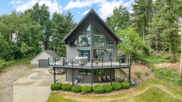 13832 Grandview Dr, Cement City, MI 49233 - back of house with an outbuilding, a detached garage, a deck, and a patio area