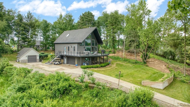 13832 Grandview Dr, Cement City, MI 49233 - rear view of property featuring a wooden deck, a lawn, an outbuilding, driveway, and view of wooded area