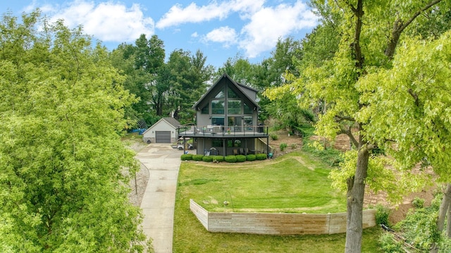 13832 Grandview Dr, Cement City, MI 49233 - rear view of house featuring concrete driveway, an outbuilding, a yard, a garage, and a wooden deck