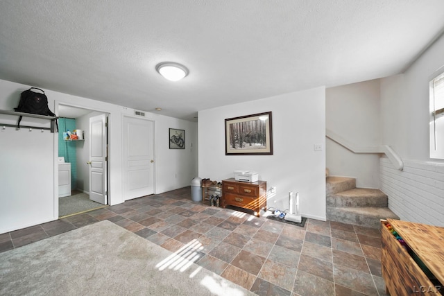 13832 Grandview Dr, Cement City, MI 49233 - foyer with washer / clothes dryer, stone finish floors, stairs, and a textured ceiling