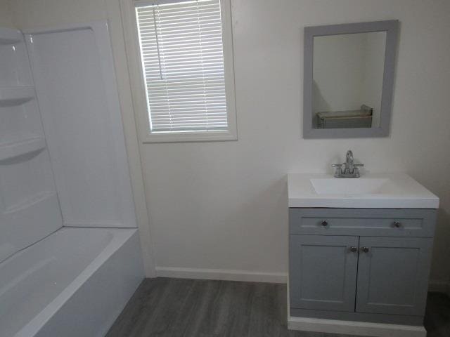 516 Cedar St, Owosso, MI 48867 - bathroom with vanity, wood finished floors, and shower / bathtub combination