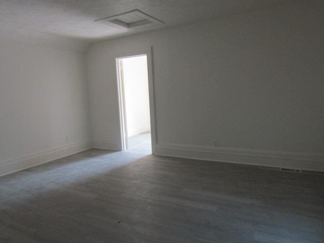 516 Cedar St, Owosso, MI 48867 - unfurnished room featuring wood finished floors and vaulted ceiling