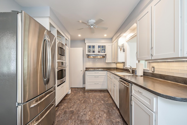 2104 Winchell Dr, Ann Arbor, MI 48104 - kitchen with appliances with stainless steel finishes, dark countertops, a ceiling fan, decorative backsplash, and white cabinets
