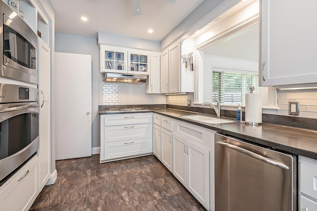 2104 Winchell Dr, Ann Arbor, MI 48104 - kitchen with appliances with stainless steel finishes, dark countertops, white cabinetry, glass insert cabinets, and tasteful backsplash