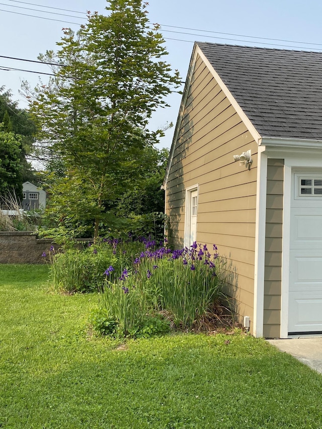 2104 Winchell Dr, Ann Arbor, MI 48104 - view of property exterior featuring roof with shingles, a garage, and a yard