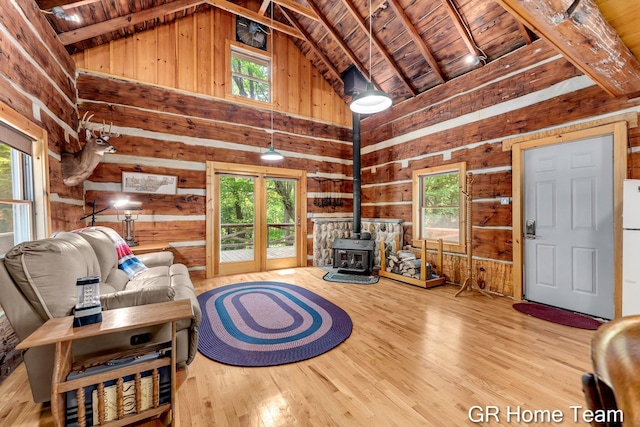 8607 S Ferris Ave, Newaygo, MI 49337 - living room with a wood stove, wood walls, high vaulted ceiling, a wooden ceiling with exposed beams, and wood finished floors