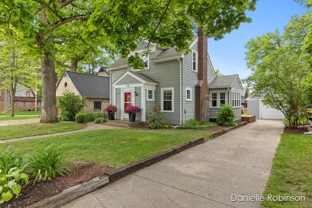 1448 Hall St SE, Grand Rapids, MI 49506 - view of front of house featuring an outdoor structure, a chimney, a front yard, roof with shingles, and a garage