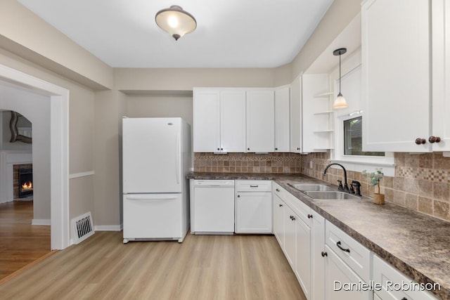 1448 Hall St SE, Grand Rapids, MI 49506 - kitchen featuring white appliances, light wood finished floors, dark countertops, white cabinets, and tasteful backsplash