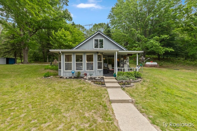 10667 220th Ave, Big Rapids, MI 49307 - view of front of home with covered porch, a front lawn, and an outbuilding