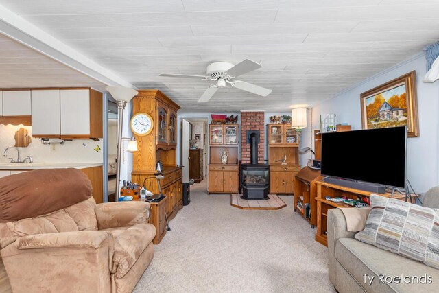 10667 220th Ave, Big Rapids, MI 49307 - living area featuring a wood stove, ceiling fan, and light carpet
