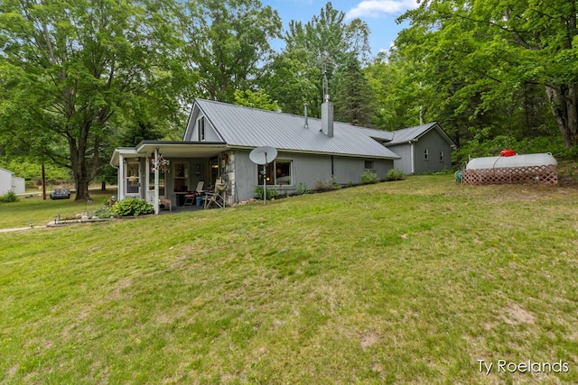 10667 220th Ave, Big Rapids, MI 49307 - rear view of property with a lawn, a metal roof, and a chimney