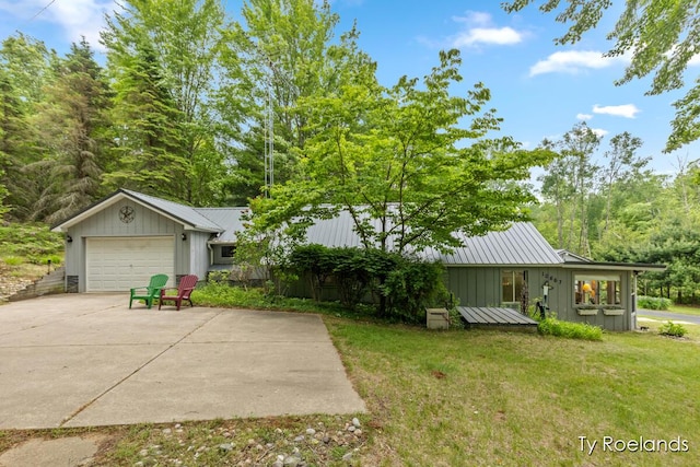 10667 220th Ave, Big Rapids, MI 49307 - view of grassy yard featuring concrete driveway and a garage