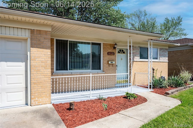 30320 Moulin Ave, Warren, MI 48088 - entrance to property with covered porch, brick siding, and a garage
