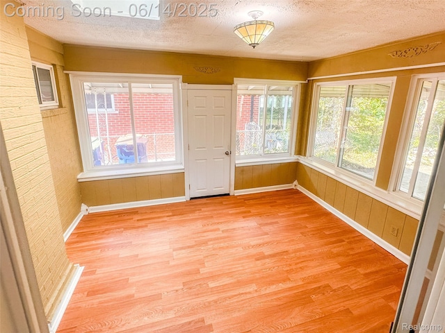 30320 Moulin Ave, Warren, MI 48088 - empty room with light wood-style floors, a textured ceiling, and wood walls