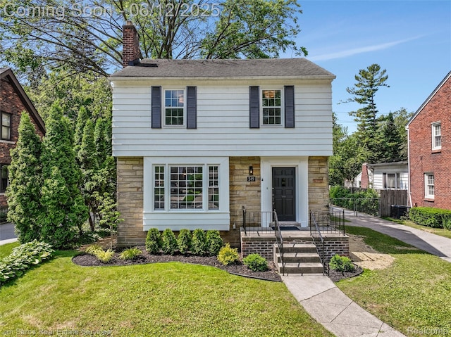 249 Ridgemont Rd, Grosse Pointe, MI 48236 - colonial home featuring stone siding and a chimney