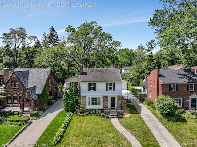 249 Ridgemont Rd, Grosse Pointe, MI 48236 - view of front of house featuring a front lawn, an outdoor structure, a chimney, and stone siding