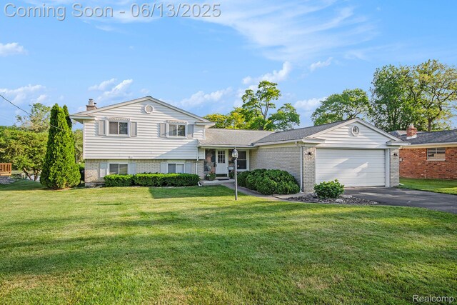3255 School House Dr, Waterford, MI 48329 - split level home featuring a garage, driveway, a front yard, and brick siding