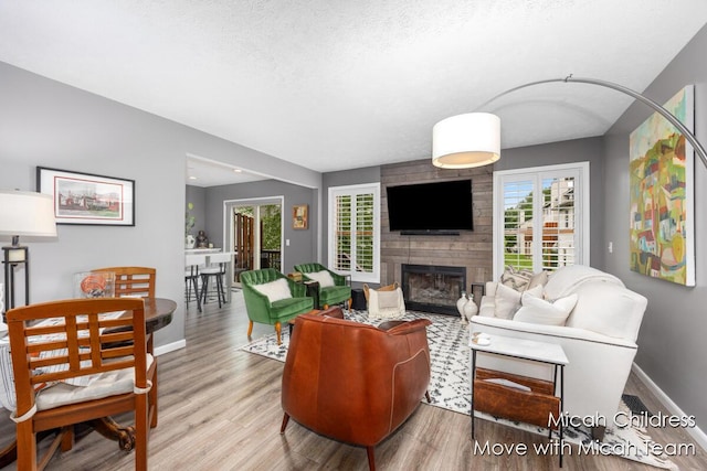 2321 S Highland View Cir SE, Grand Rapids, MI 49506 - living area featuring wood finished floors, a large fireplace, healthy amount of natural light, and a textured ceiling