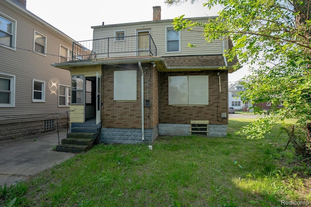 2476 Ford St, Detroit, MI 48238 - rear view of property featuring a balcony, entry steps, a yard, and a chimney