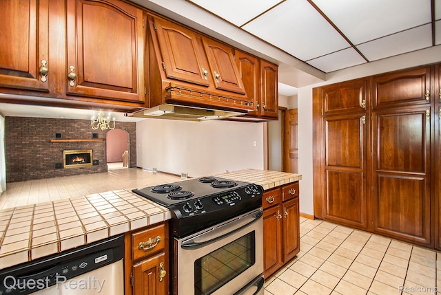 14050 Shannon Dr, Cement City, MI 49233 - kitchen featuring stainless steel electric range oven, tile counters, dishwasher, light tile patterned floors, and a fireplace