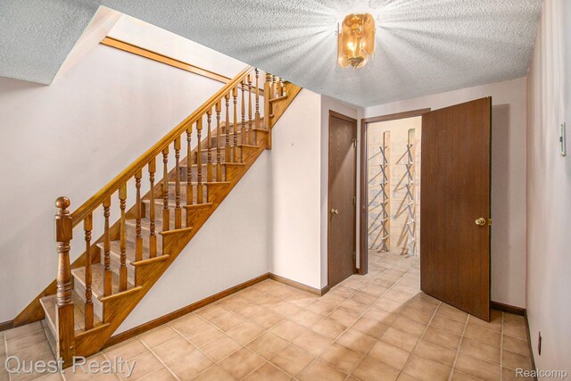 14050 Shannon Dr, Cement City, MI 49233 - stairway with a textured ceiling and tile patterned floors
