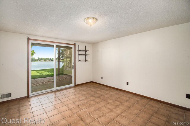 14050 Shannon Dr, Cement City, MI 49233 - unfurnished room featuring a water view and a textured ceiling