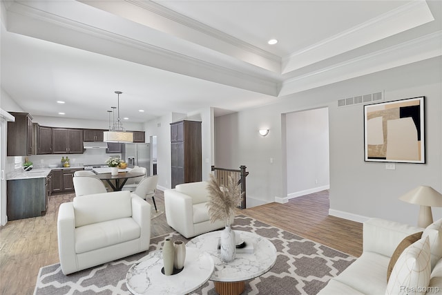 47467 Bayside Cir W, Chesterfield, MI 48047 - living room featuring light wood-type flooring, recessed lighting, a tray ceiling, and crown molding