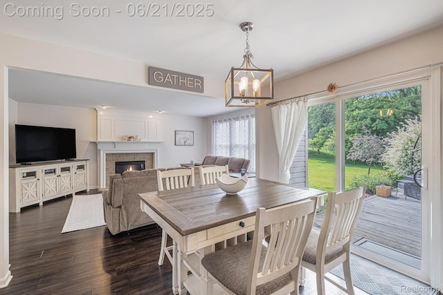 894 Canyon Creek Dr, Holly, MI 48442 - dining space with a chandelier, dark wood-type flooring, and a tiled fireplace