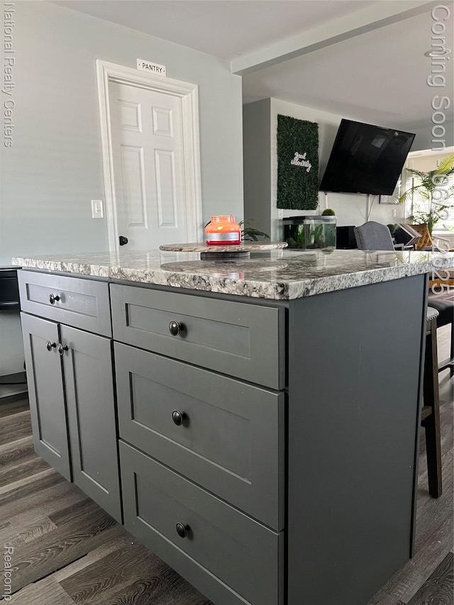 13203 Frazho Rd, Warren, MI 48089 - kitchen with gray cabinets, dark wood-style floors, light stone counters, and a kitchen breakfast bar