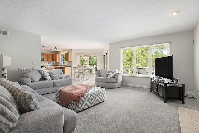 5448 Waterfield Ct, Ann Arbor, MI 48108 - living room featuring light colored carpet, a textured ceiling, and a chandelier