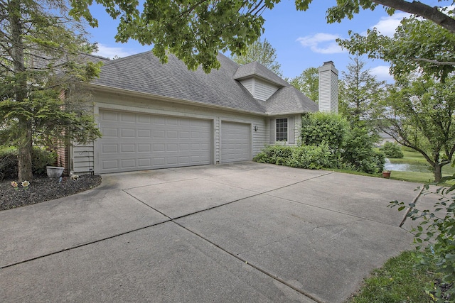 5448 Waterfield Ct, Ann Arbor, MI 48108 - traditional-style home featuring driveway, a garage, roof with shingles, a chimney, and a water view