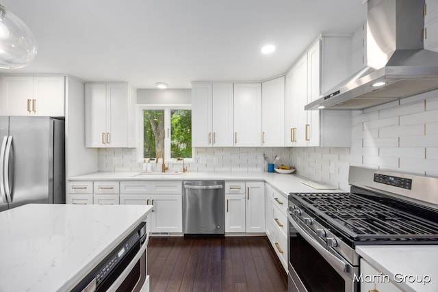 2243 Cambridge Dr SE, Grand Rapids, MI 49506 - kitchen featuring stainless steel appliances, wall chimney range hood, light stone counters, white cabinets, and dark wood finished floors