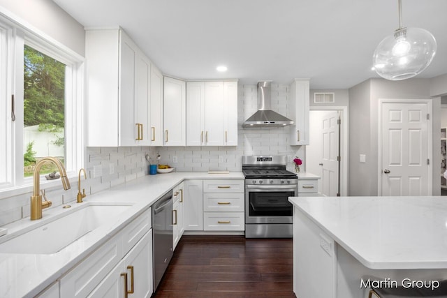 2243 Cambridge Dr SE, Grand Rapids, MI 49506 - kitchen featuring wall chimney range hood, stainless steel appliances, dark wood-style floors, decorative backsplash, and white cabinetry