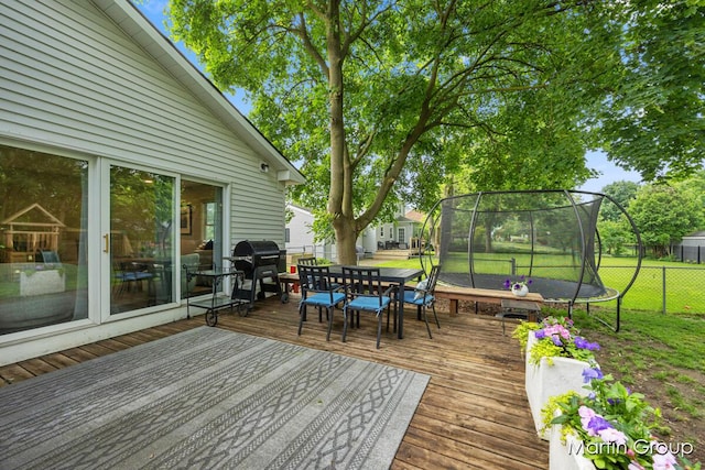 2243 Cambridge Dr SE, Grand Rapids, MI 49506 - wooden deck with a trampoline, outdoor dining area, and grilling area