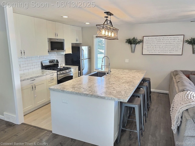 8811 Coyle Dr, Pinckney, MI 48169 - kitchen featuring stainless steel appliances, white cabinetry, wood finished floors, and recessed lighting