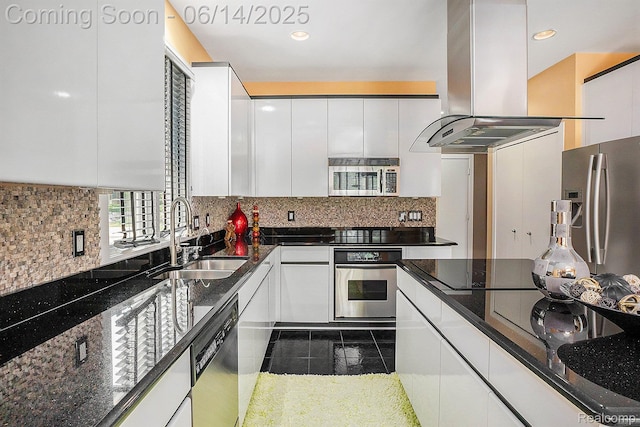4322 Darlene Dr, Commerce Twp, MI 48382 - kitchen with stainless steel appliances, island range hood, white cabinets, backsplash, and recessed lighting