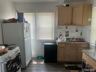 19131 Cliff St, Detroit, MI 48234 - kitchen with white gas range, wood finished floors, and light brown cabinets