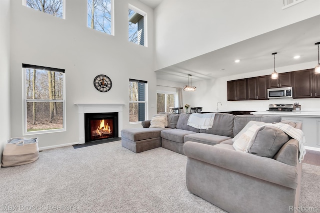 2799 Gallop Way, Saline, MI 48176 - living area featuring carpet floors, a fireplace with flush hearth, a high ceiling, and recessed lighting