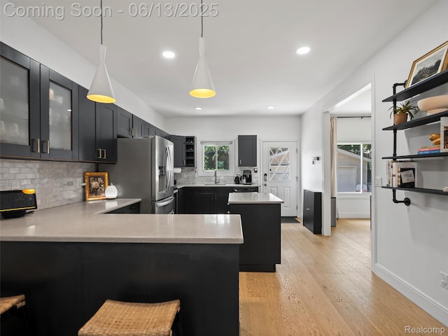 2147 Princeton Rd, Berkley, MI 48072 - kitchen with stainless steel fridge, light countertops, decorative backsplash, light wood-style floors, and recessed lighting